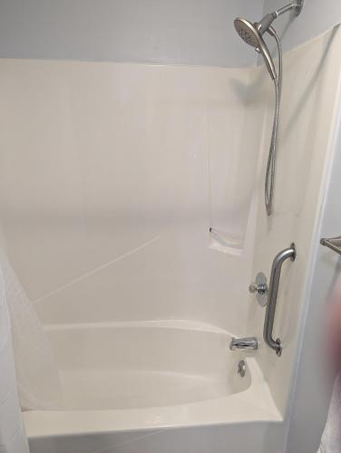 a white bath tub with a shower head in a bathroom at Double Take! Renovated Vacation Home in Panama City Beach