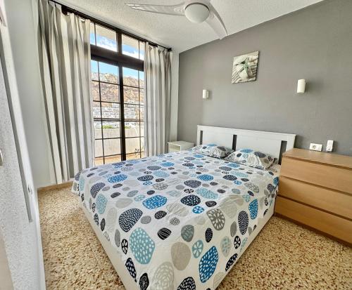 Un dormitorio con una cama y una ventana grande. en Las Fresas Apartments, en Puerto Rico de Gran Canaria