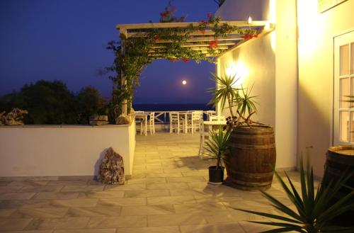 an outdoor patio at night with a table and chairs at Paros Blue Dolphin FULLY RENOVATED by RIVEA GROUP in Chrissi Akti