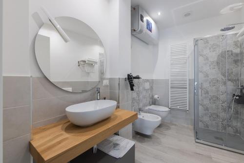 a bathroom with a sink and a toilet and a mirror at Casa Teresa - Luminosa eleganza in Asti