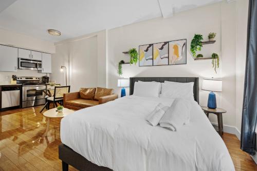 a bedroom with a large white bed and a living room at Furnished Apartment in Downtown in Boston