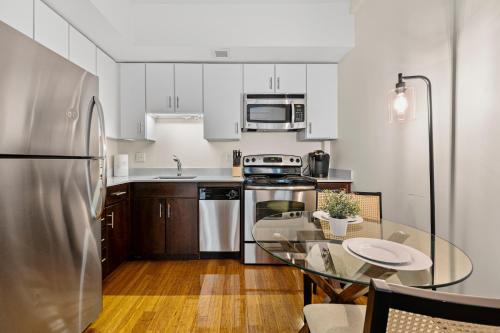 a kitchen with a table and a stainless steel refrigerator at Furnished Apartment in Downtown in Boston