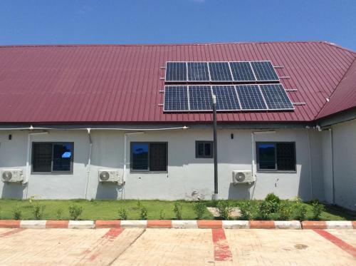 a house with a red roof with solar panels on it at RockView Hotel in Tongo