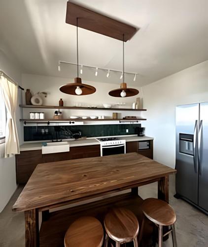 a kitchen with a wooden table and a refrigerator at Country Club en Capala in Chapala