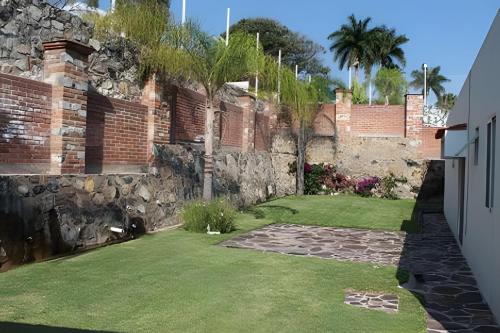 a backyard with a stone wall and a grass yard at Country Club en Capala in Chapala
