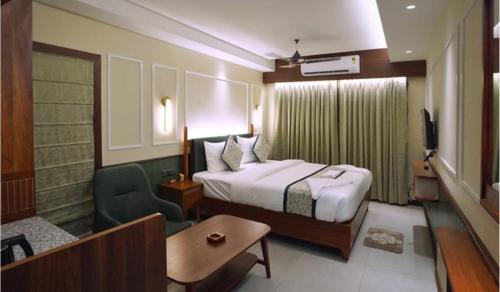 a hotel room with a bed and a chair at Hotel Venture Grand in Mumbai