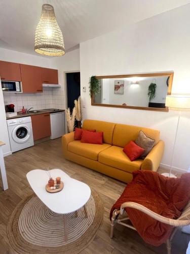 un salon avec un canapé jaune et une table dans l'établissement Les Charmes - C24B, à Eppe-Sauvage