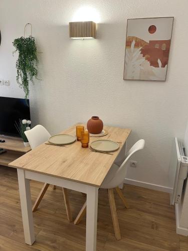 une table à manger avec deux chaises et une table avec deux assiettes dans l'établissement Les Charmes - C24B, à Eppe-Sauvage