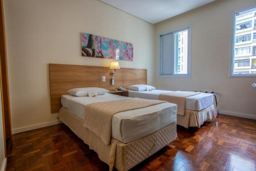 a bedroom with two beds in a room at Hotel Amália in Sao Paulo