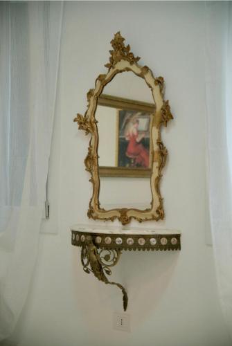 a mirror on a wall with a woman in a painting at Affittacamere Ca' Cini in Monselice