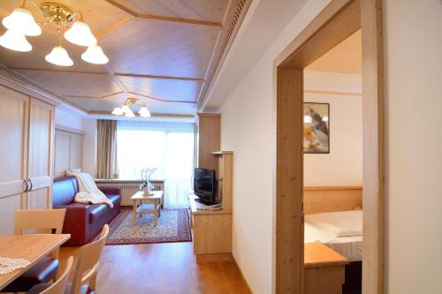 a room with a bed and a living room at Residence Isabell in Selva di Val Gardena