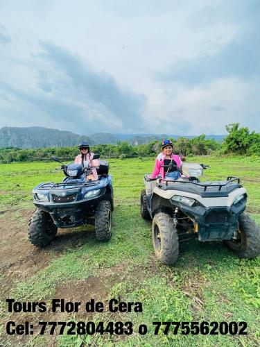 two people riding on atvs in a field at Flor de Cera in Tepoztlán