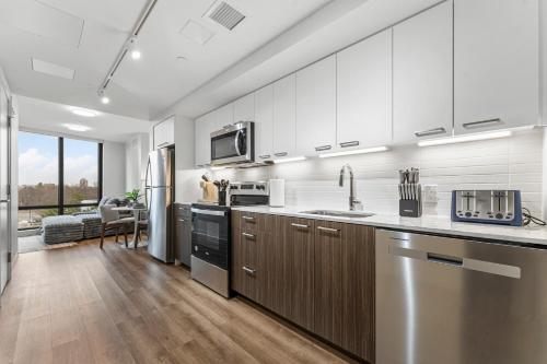 a kitchen with stainless steel appliances and wood floors at Furnished Luxury Apartment Next to Harvard Stadium in Boston