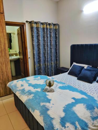 a bedroom with a bed with a blue comforter at Private & Cozy 2-Bedroom Full Apartment for Families E11 Islamabad in Islamabad