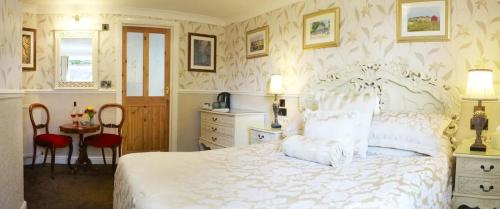 a bedroom with a white bed and a table and chairs at Castle By The Sea Scarborough in Scarborough