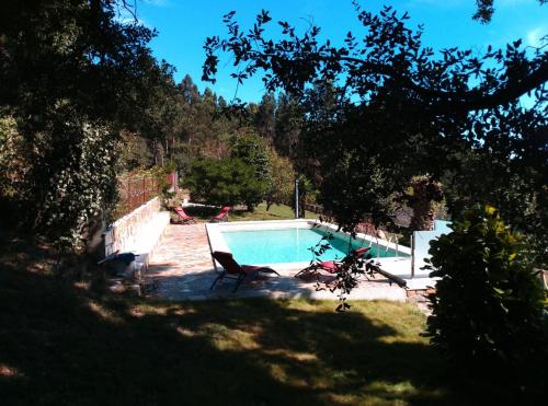 a pool in a yard with two chairs next to it at Casa Quercus Galicia, a 17 minutos de Santiago! in A Estrada