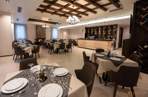 a restaurant with tables and chairs and a wine cellar at PineHill Hotel, Restaurant , Pool & Spa - RAZEM in Razëm