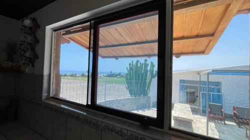 een raam in een kamer met uitzicht op een cactus bij Mejía CampoMar in Mejia