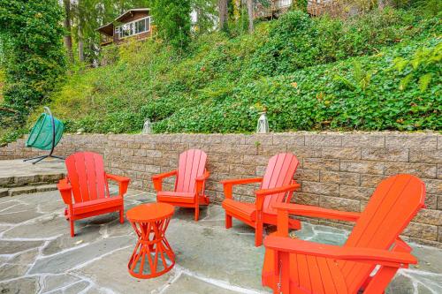 four red chairs and a table in front of a brick wall at Pet-Friendly Studio with Fire Pit in Olympia! in Olympia