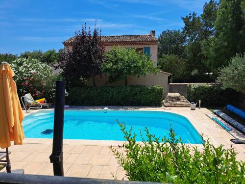 une petite piscine bleue avec une maison en arrière-plan dans l'établissement Maison en Provence verte classée 3 étoiles, à Camps-la-Source