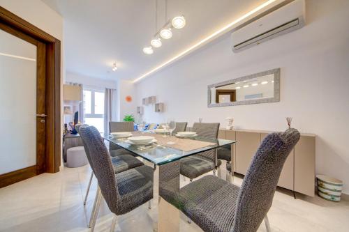 a dining room with a glass table and chairs at Amazing Location in St Julian's, Paceville 2 Bedroom, with Balcony by Vaganza in St Julian's