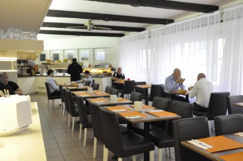 a dining room with people sitting at tables at Acquarello Swiss Quality Hotel in Lugano
