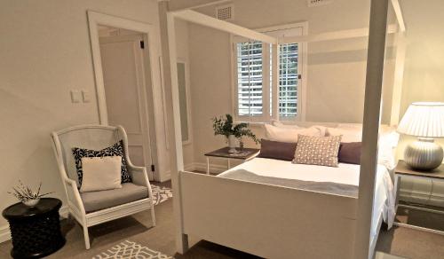 a bedroom with a canopy bed and a chair at Southey House in Kloof