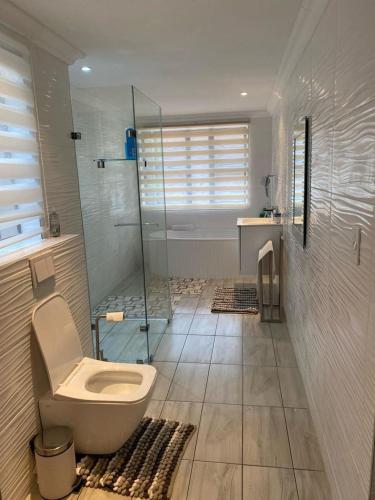 a bathroom with a toilet and a glass shower at Peaceful picturesque Pecanwood in Hartbeespoort