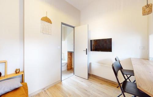 - une salle à manger avec une table et une porte menant à une chambre dans l'établissement Studio, aire de loisirs avec piscine, à Marigny