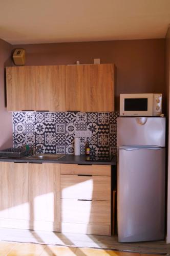 une cuisine avec un réfrigérateur en acier inoxydable et un micro-ondes dans l'établissement Charmant Appartement à St Aygulf, à Fréjus