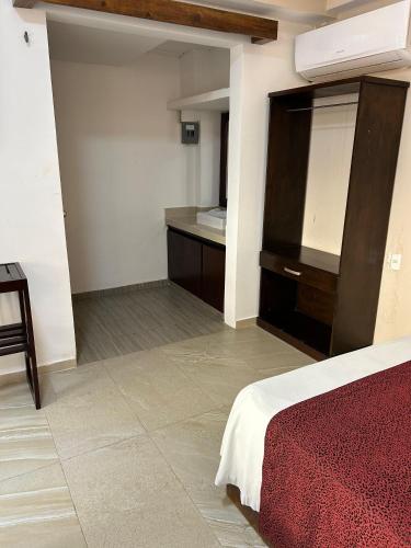 a bedroom with a bed and a sink in it at Framfor Inn in Chetumal