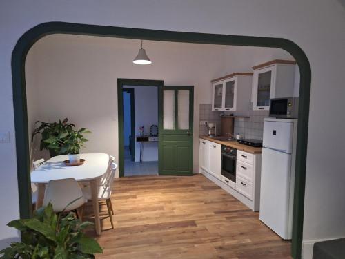 une cuisine avec une table et une porte verte dans l'établissement Les racines de Montchapet, à Dijon