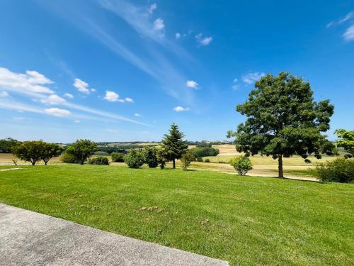 un champ verdoyant avec des arbres et un ciel bleu dans l'établissement NOUVEAUTE Maison avec vue dominante sur la campagne, à Lamontjoie
