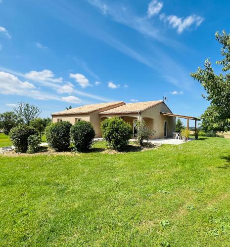 une maison avec une pelouse verte devant elle dans l'établissement NOUVEAUTE Maison avec vue dominante sur la campagne, à Lamontjoie