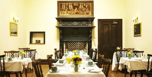 a dining room with tables and chairs and a fireplace at Castle By The Sea Scarborough in Scarborough
