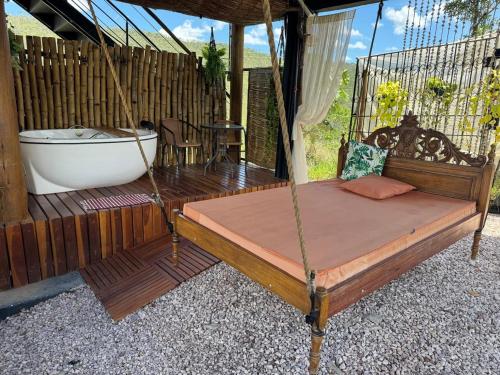 a bed sitting on a deck with a bath tub at Rustik in Alto Paraíso de Goiás