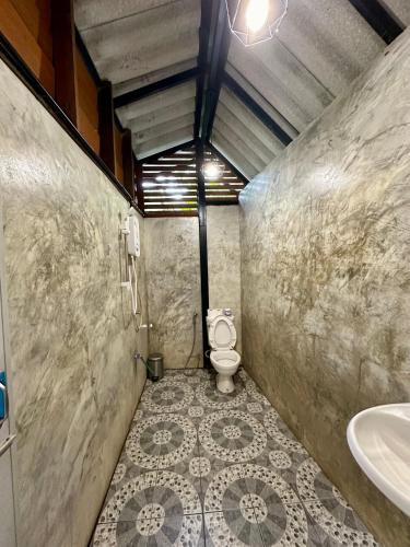 a bathroom with a toilet and a sink at ไชยพล โฮมสเตย์ หมู่บ้านแม่กำปอง in Ban Pok Nai