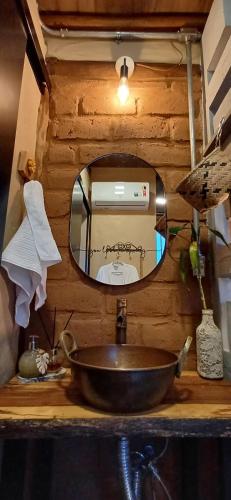 a bathroom sink with a mirror on a wooden counter at Rustik in Alto Paraíso de Goiás