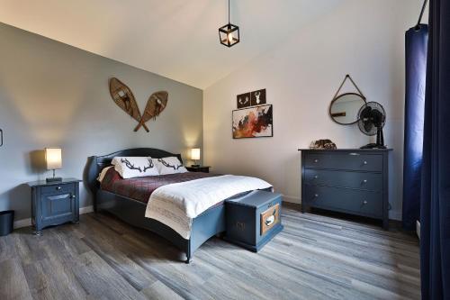 a bedroom with a bed and two night stands and two lamps at Chalet Le Cerf du Lac in Disraeli