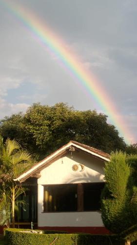 a rainbow in the sky over a house at Hotel Rancho Las Margaritas in Valle de Bravo