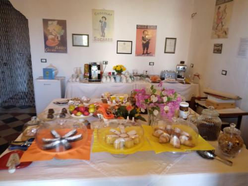a table with plates of food and flowers on it at Dimora Maltese in Morciano di Leuca