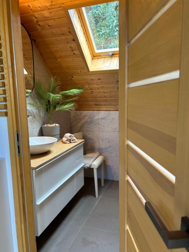a bathroom with a sink and a skylight at das haus - kisház a völgyben in Tarján