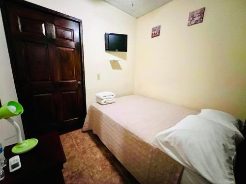 a small bedroom with a bed and a door at HOTEL Ecológico BLUEROCK in David