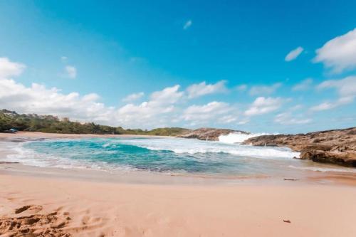 una playa de arena con olas en el océano en MAS102 Manati Amaizing Studio, en Manatí