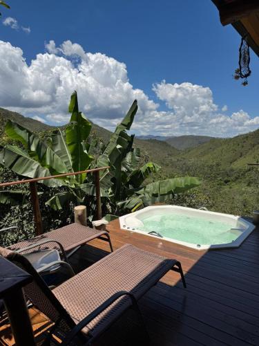 a hot tub on a deck with a view of the mountains at Rustik in Alto Paraíso de Goiás