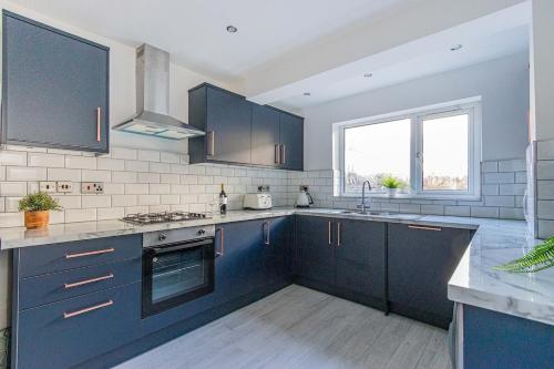 a kitchen with blue cabinets and a sink at The Luxury Home Free Parking 10 Min Walk to Cardiff Town in Cardiff