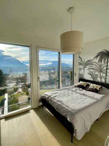 une chambre avec un lit et une grande fenêtre dans l'établissement Luxueuse villa Annecy, à Argonay