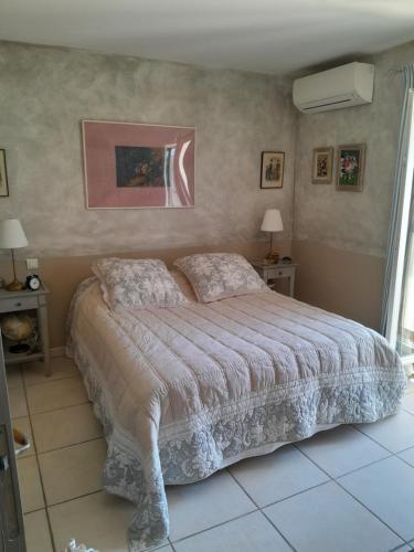 une chambre avec un grand lit dans une pièce dans l'établissement La Bartavelle, à Eyragues