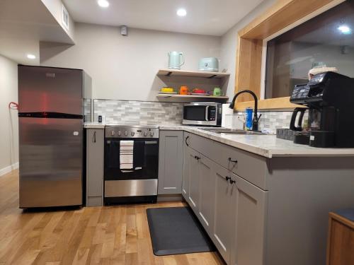 a kitchen with a stainless steel refrigerator and a sink at The Suite Treat in Whitehorse