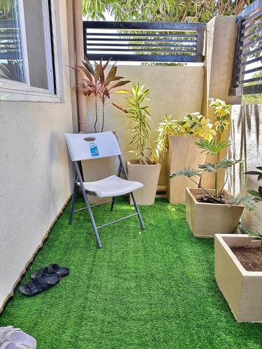 a table and chair on the grass in a garden at Bahai ni Jhane in Calatagan